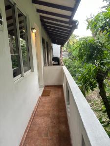 eine Veranda eines Hauses mit Balkon in der Unterkunft Mango Tree Budget Home Stay in Homagama