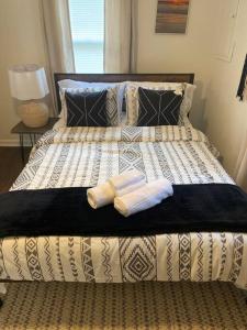 a bed with two pillows and two towels on it at Boho Hideway! in New Albany