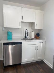 a kitchen with white cabinets and a stainless steel dishwasher at Boho Hideway! in New Albany