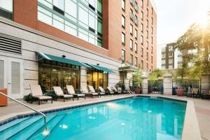 a swimming pool with chairs and a building at Hampton Inn & Suites Little Rock-Downtown in Little Rock