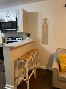 a kitchen with two stools and a counter with a microwave at Boho Hideway! in New Albany