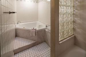 a bathroom with a tub and a tiled floor at Hilton Cincinnati Netherland Plaza in Cincinnati