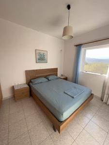 a bedroom with a large bed with a window at Urban Blue House in Agios Nikolaos