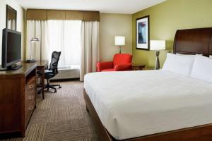 a hotel room with a bed and a desk and a television at Hilton Garden Inn Lake Mary in Lake Mary