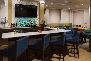 a bar in a restaurant with blue chairs at Hilton Garden Inn Lake Mary in Lake Mary