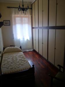 een slaapkamer met een bed en een groot raam bij Villa Debora in Lucca