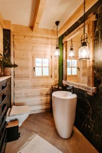 ein Badezimmer mit einer weißen Badewanne und einer Holzwand in der Unterkunft Chata za wsią in Kluszkowce