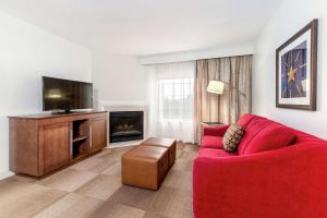 sala de estar con sofá rojo y TV de pantalla plana en Hampton Inn & Suites Bethlehem en Bethlehem