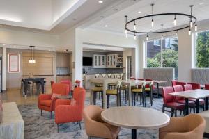 a restaurant with tables and chairs and a bar at Hilton Garden Inn Madison West/Middleton in Middleton