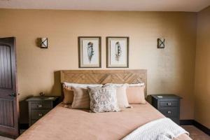 a bedroom with a bed with three pictures on the wall at Hemsley Ranch and Guest House in Preston