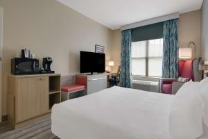 una camera d'albergo con letto e TV di Hilton Garden Inn Madison West/Middleton a Middleton