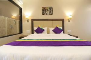 um quarto com uma cama grande e almofadas roxas em ROYAL HERITAGE em Mahabaleshwar