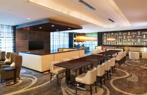 a restaurant with tables and chairs and a bar at Hilton Kansas City Airport in Kansas City