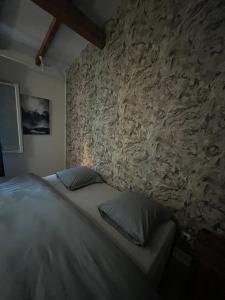 1 dormitorio con cama y pared de piedra en appart hôtel le 8 LE DUPLEX en Mâcon