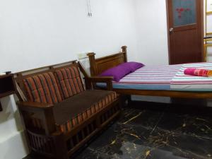 1 dormitorio con 1 cama y 1 silla en Wilpattu buma, en Nochchiyagama