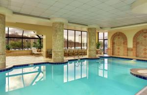 a pool in a hotel lobby with a large swimming pool at Embassy Suites Tysons Corner in Tysons Corner