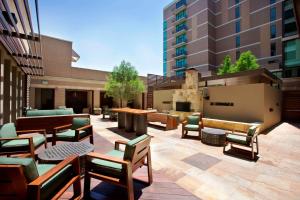 un patio con sedie e tavoli all'interno di un edificio di The Highland Dallas, Curio Collection by Hilton a Dallas