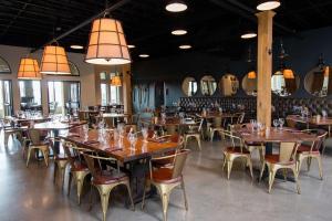 un restaurante con mesas de madera, sillas y luces en Hampton Inn & Suites Braselton, en Braselton