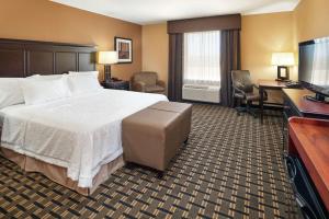 a hotel room with a bed and a flat screen tv at Hampton Inn Sweetwater in Sweetwater