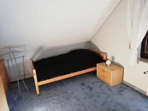 a small bedroom with a black bed and a dresser at Ferienwohnung „An der olen Au“ in Tönnhausen
