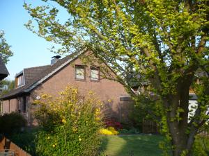 a brick house with a tree in the yard at Ferienwohnung „An der olen Au“ in Tönnhausen