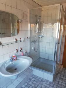 a white bathroom with a sink and a shower at Ferienwohnung „An der olen Au“ in Tönnhausen