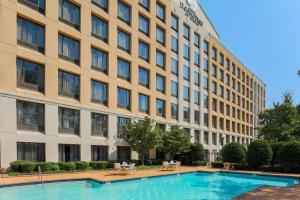 a hotel with a swimming pool in front of a building at DoubleTree by Hilton Atlanta Airport in Atlanta