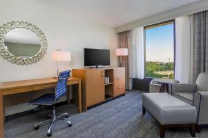 a hotel room with a desk and a chair and a television at DoubleTree by Hilton Atlanta Airport in Atlanta
