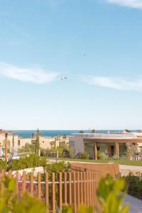 an airplane flying over a building with the ocean in the background at White Shell Beach Villas in Porches