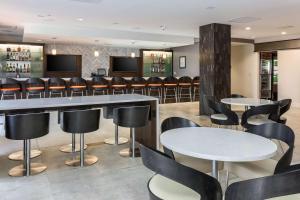 DoubleTree by Hilton Atlanta Airport في أتلانتا: بار في مطعم به طاولات وكراسي