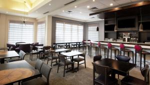restauracja ze stołami i krzesłami oraz bar w obiekcie Hilton Garden Inn Philadelphia-Fort Washington w mieście Fort Washington