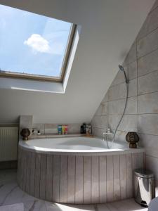 a bathroom with a bath tub with a window at Green Dream Apartment Szaunával in Miskolc