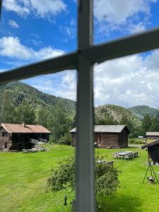 einen Blick aus einem Fenster auf ein Feld und Gebäude in der Unterkunft Sevletunet B&B and Cabins in Rødberg