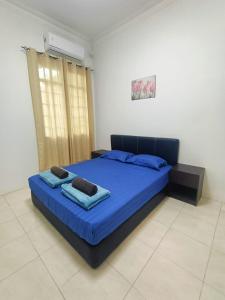 1 dormitorio con 1 cama azul en una habitación en Miri Morsjaya HOMESTAY, en Miri