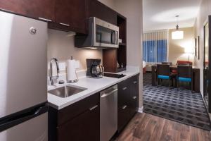 a kitchen with a sink and a microwave at Towneplace Suites By Marriott Hays in Hays