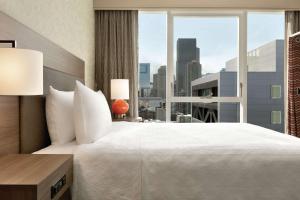 a bedroom with a large bed and a large window at Home2 Suites By Hilton Chicago River North in Chicago