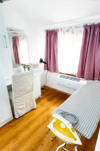a bedroom with a bed and a window with purple curtains at Guest House Star in Varna City +23 photos