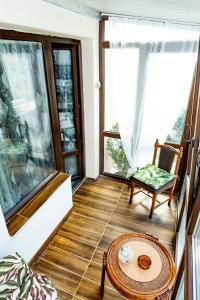 a room with a table and a chair and windows at Guest House Star in Varna City