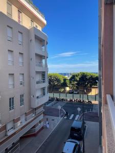 a building with cars parked in a parking lot at Appartement proche mer in Cannes