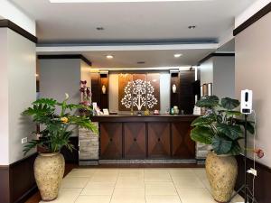a hotel lobby with a reception desk and plants at Srivichai Hotel in Nakhon Ratchasima