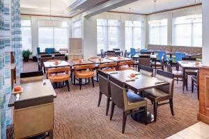 un comedor con mesas, sillas y ventanas en Hilton Garden Inn Austin North, en Austin