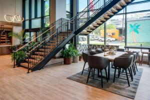 a dining room with a staircase and a table and chairs at Hilton Garden Inn Austin University Capitol District in Austin