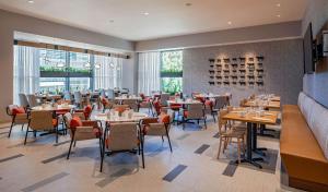 a dining room with tables and chairs and windows at Hilton Garden Inn Austin University Capitol District in Austin