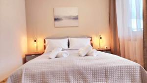 a bedroom with a white bed with two pillows at Arboro Borovets Gardens E43 in Borovets