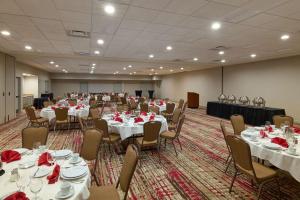 a large room with tables and chairs with red napkins at Hilton Garden Inn Bloomington in Bloomington