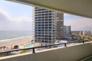 a view of the beach from the balcony of a building at Aliki Atrium Beachfront Condo in Ormond Beach