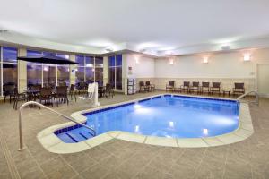 uma piscina num quarto de hotel com mesas e cadeiras em Hilton Garden Inn Detroit/Novi em Novi
