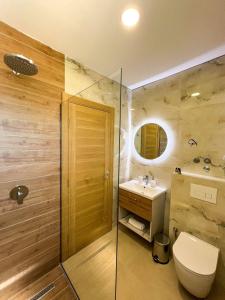 uma casa de banho com um chuveiro, um WC e um lavatório. em Square Residence em Ulcinj