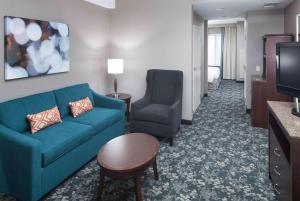 sala de estar con sofá y silla en una habitación de hotel en Hilton Garden Inn Detroit/Novi en Novi