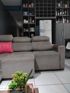 a living room with a couch and a refrigerator at Gray House 1 - JD Santiago in Londrina